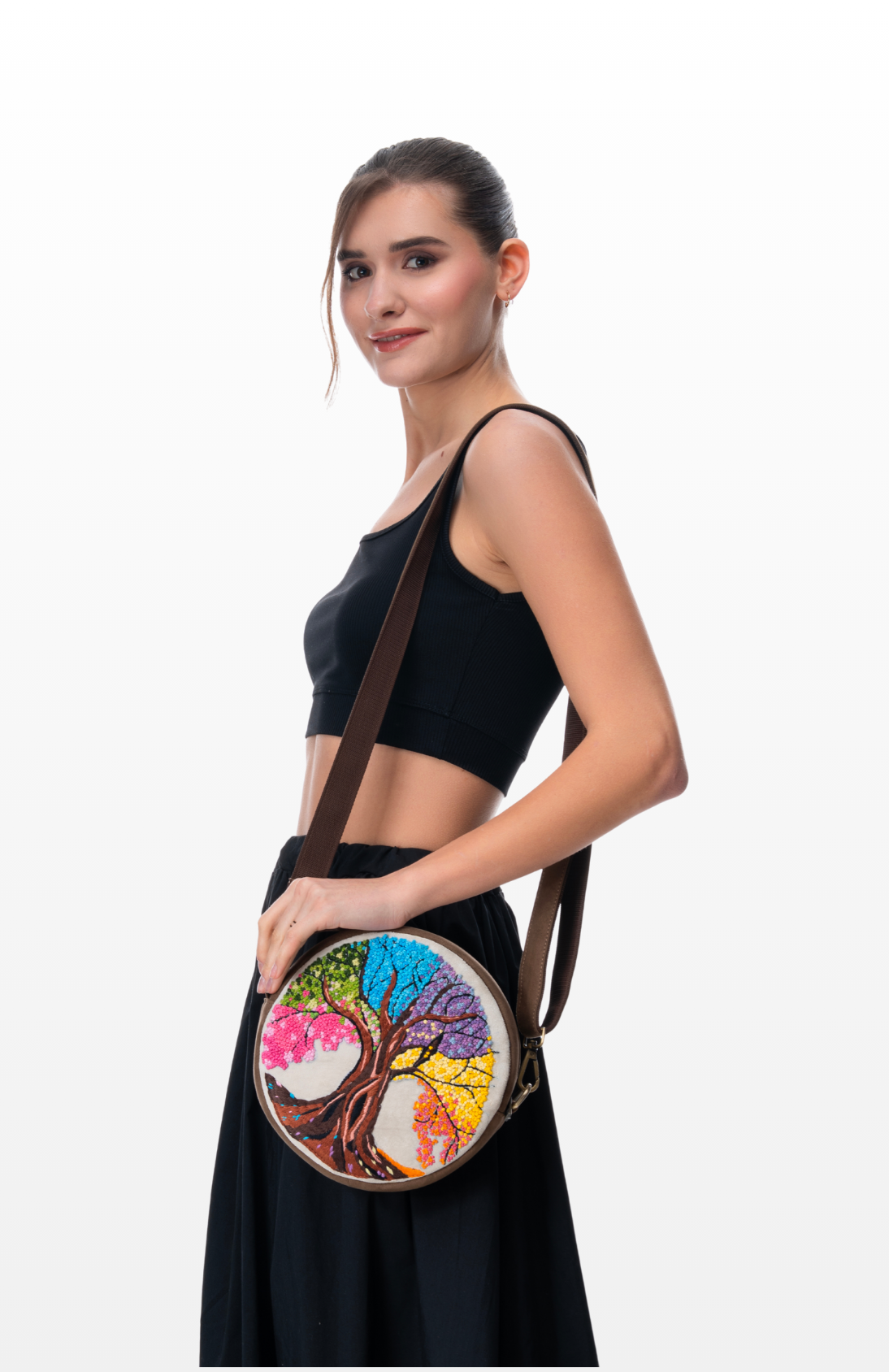 Woman wearing Eternal Bloom round sling purse by the brand Story of Strings.
