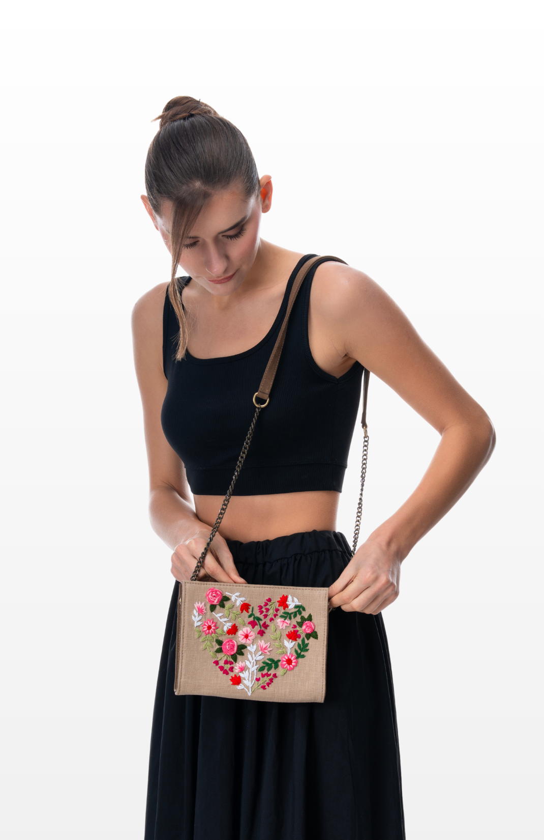Woman wearing Floral Heart sling purse by the brand Story of Strings.
