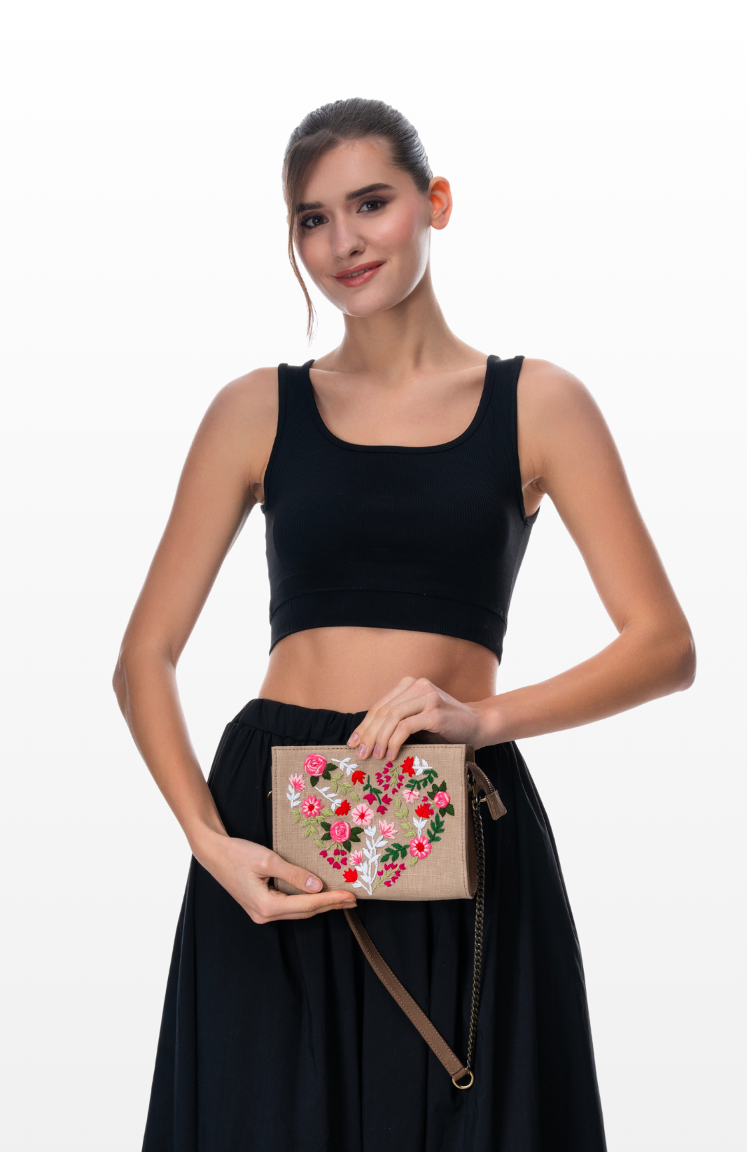 Woman holding Floral Heart sling purse by the brand Story of Strings.