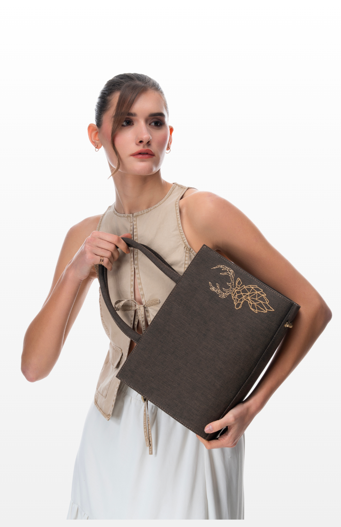 A woman holding Golden Deer (Medium Tote Bag) by the brand Story of Strings.