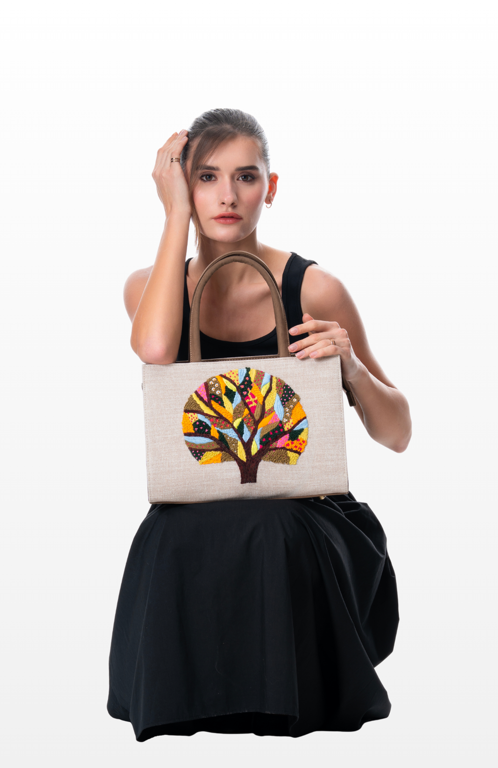 Woman holding a Harmony in Roots tote bag by the brand Story of Strings.