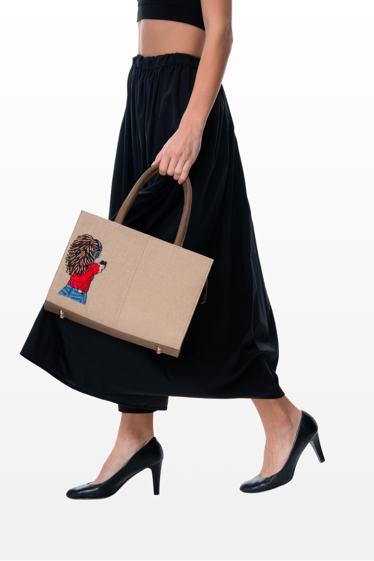 Woman carrying a Steady Aim handbag by the brand Story of Strings