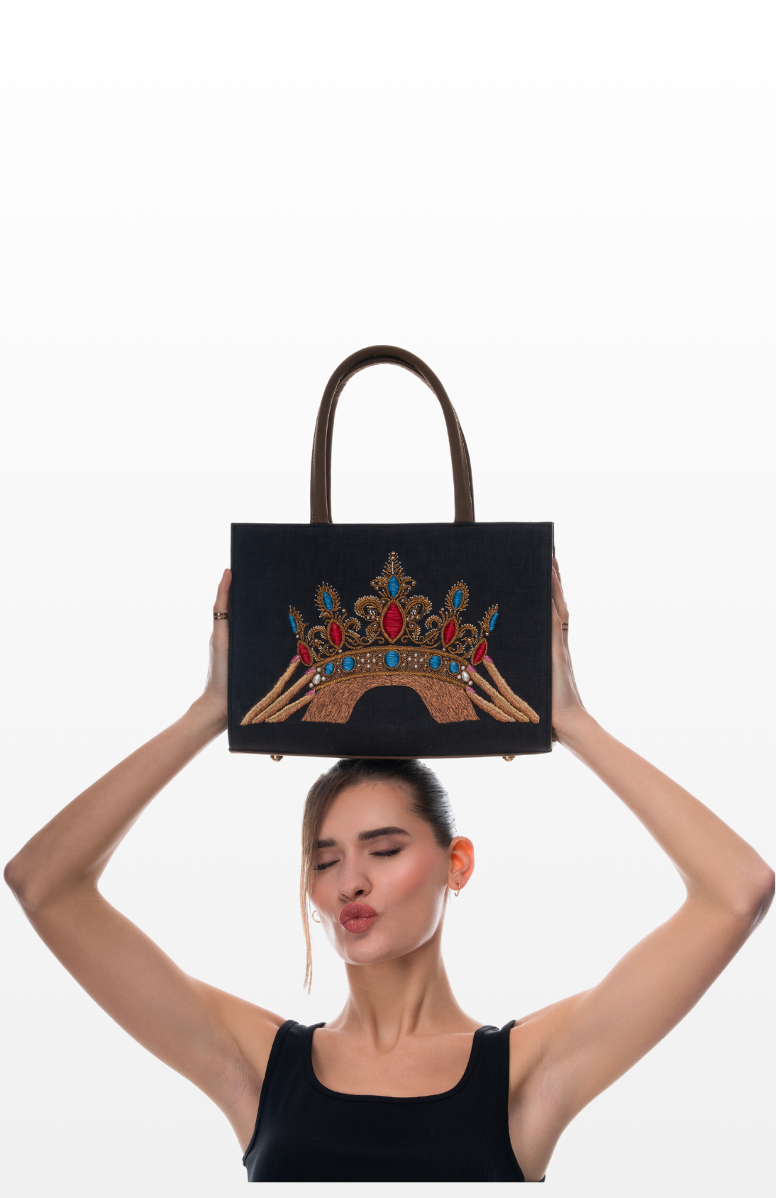 Woman holding The Crown Jewels tote bag by the brand Story of Strings.