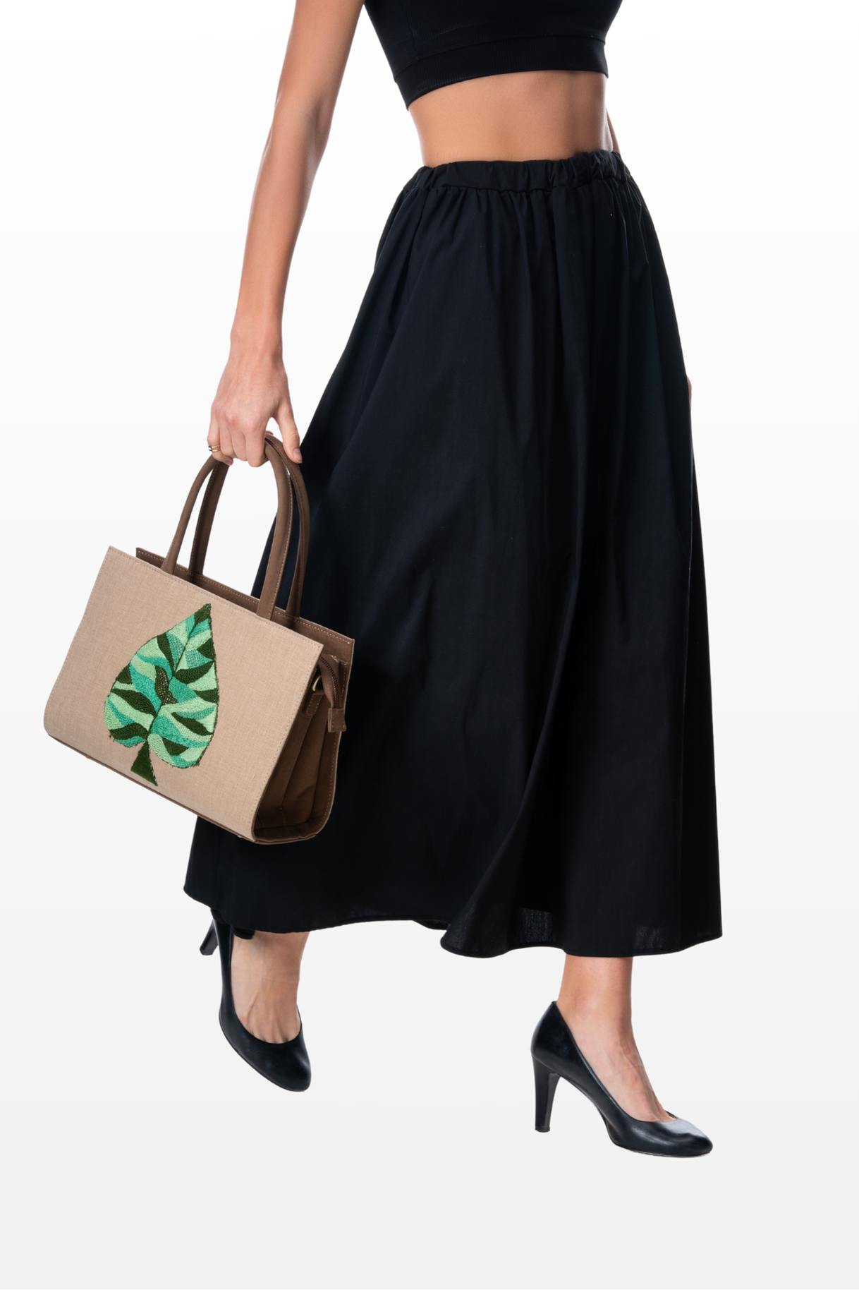 Woman carrying The Quiet Green handbag by the brand Story of Strings
