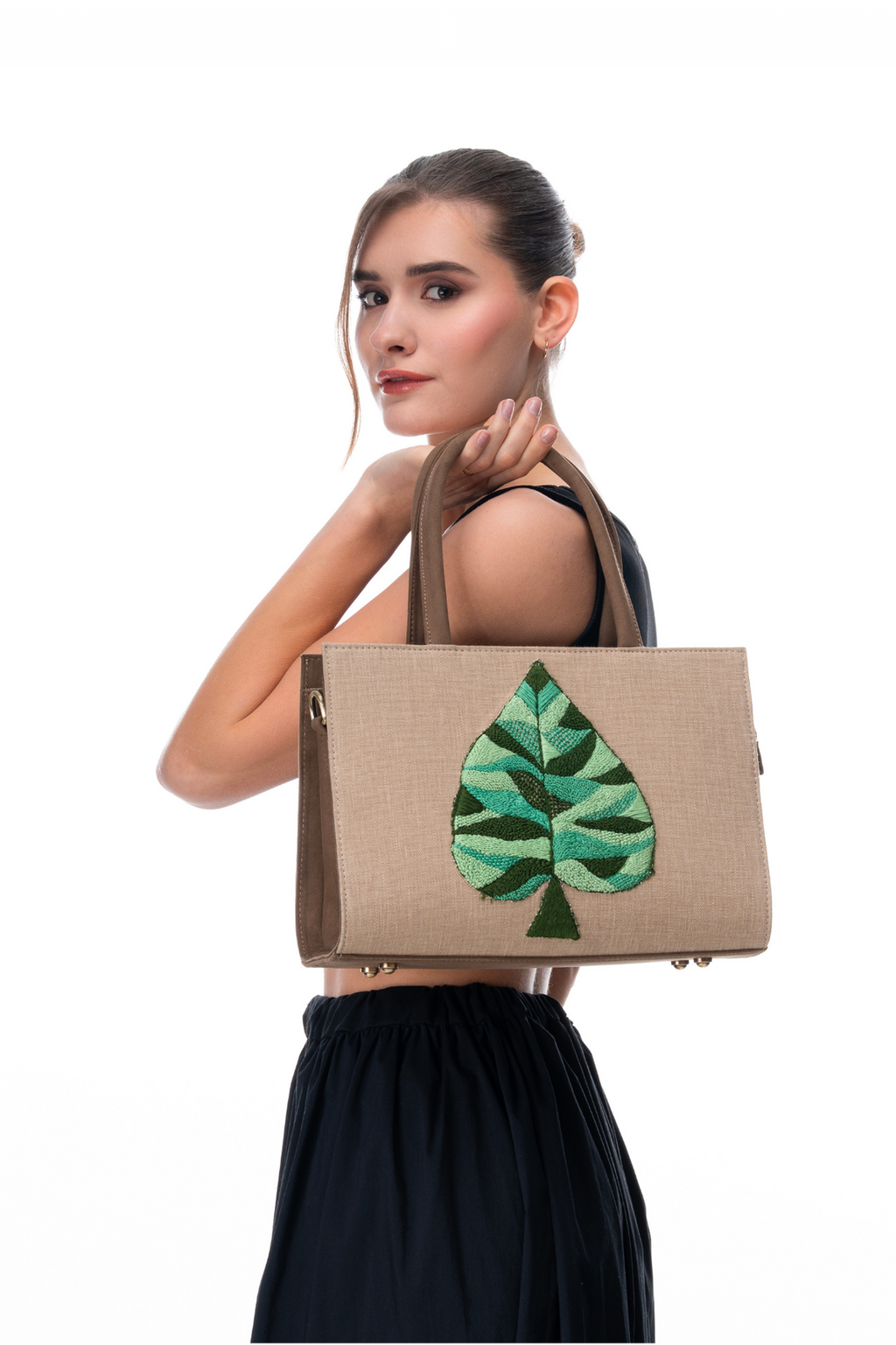Woman Holding The Quiet Green handbag by the brand Story of Strings