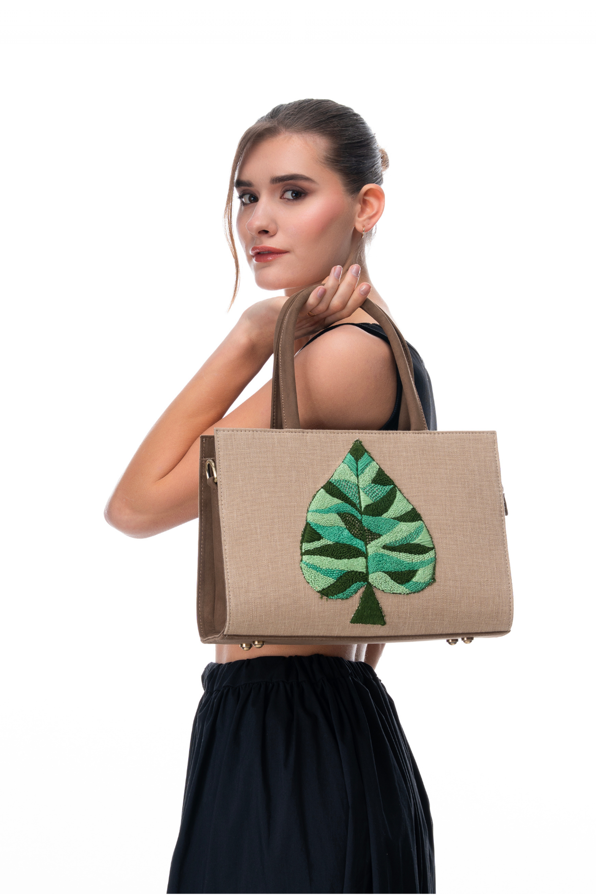 Woman Holding The Quiet Green handbag by the brand Story of Strings