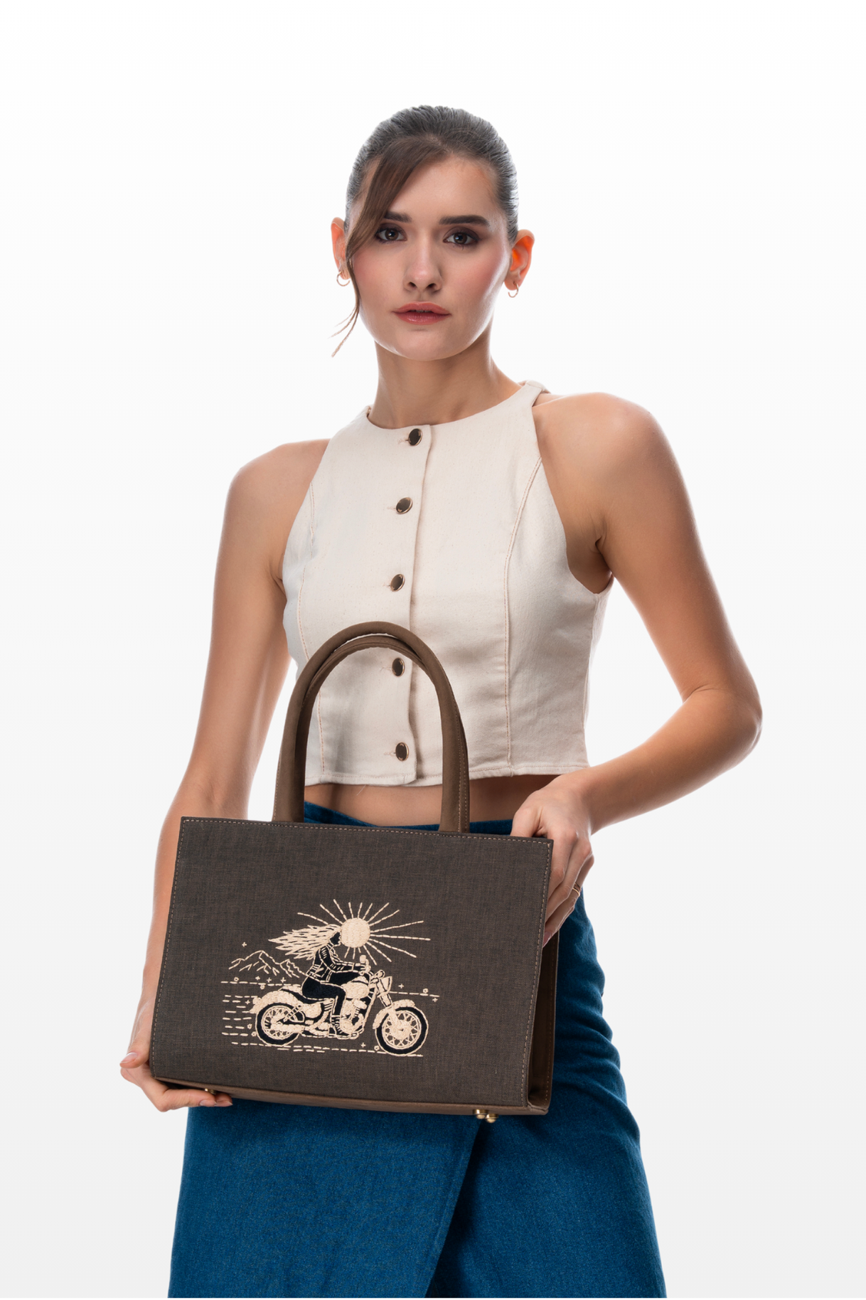 Woman holding The Silver Road medium handbag by the brand Story of Strings 