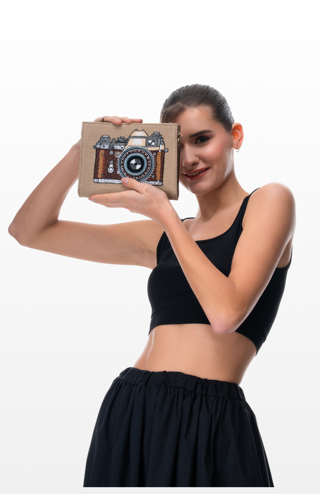 A woman holding The Vintage Lens sling purse by the brand Story of Strings.