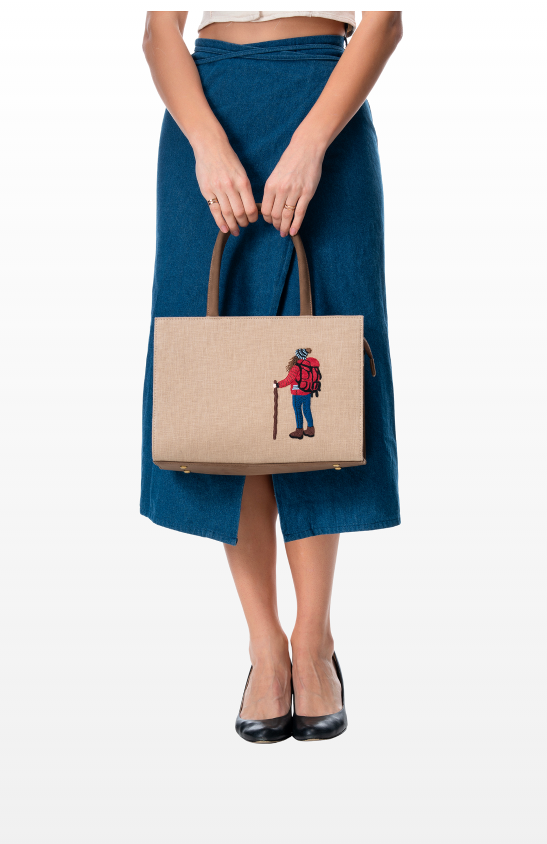A woman holding The Wanderer tote bag by the brand Story of Strings.