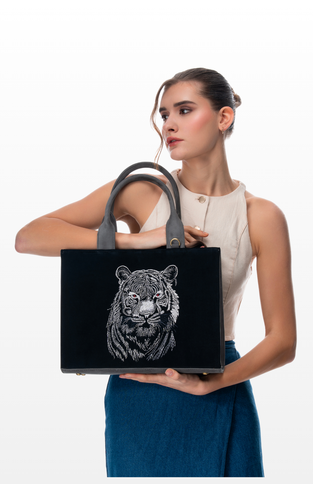 A woman holding Tiger's Pride tote bag by the brand Story of Strings.