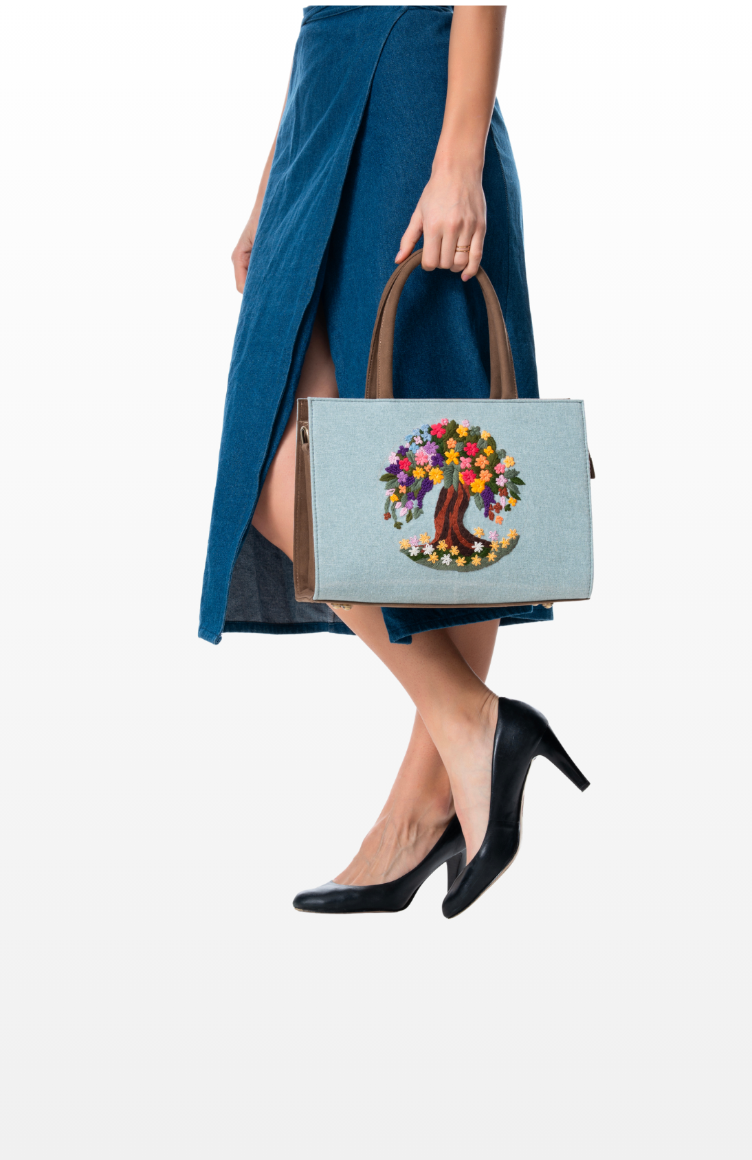 A woman holding Tree of Radiance tote bag by the brand Story of Strings.