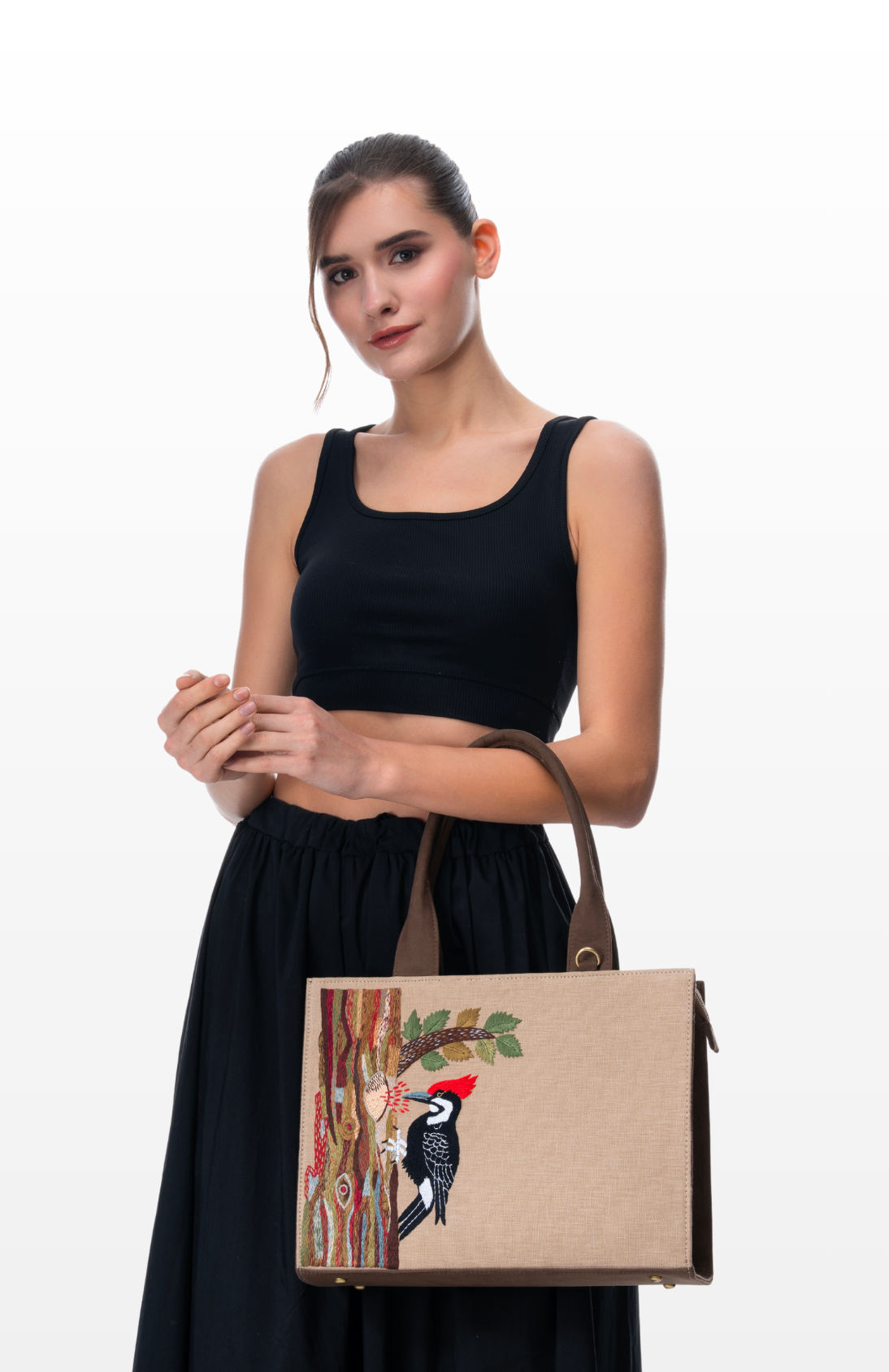 Woman wearing Woodpecker's Rhythm tote bag by the brand Story of Strings.